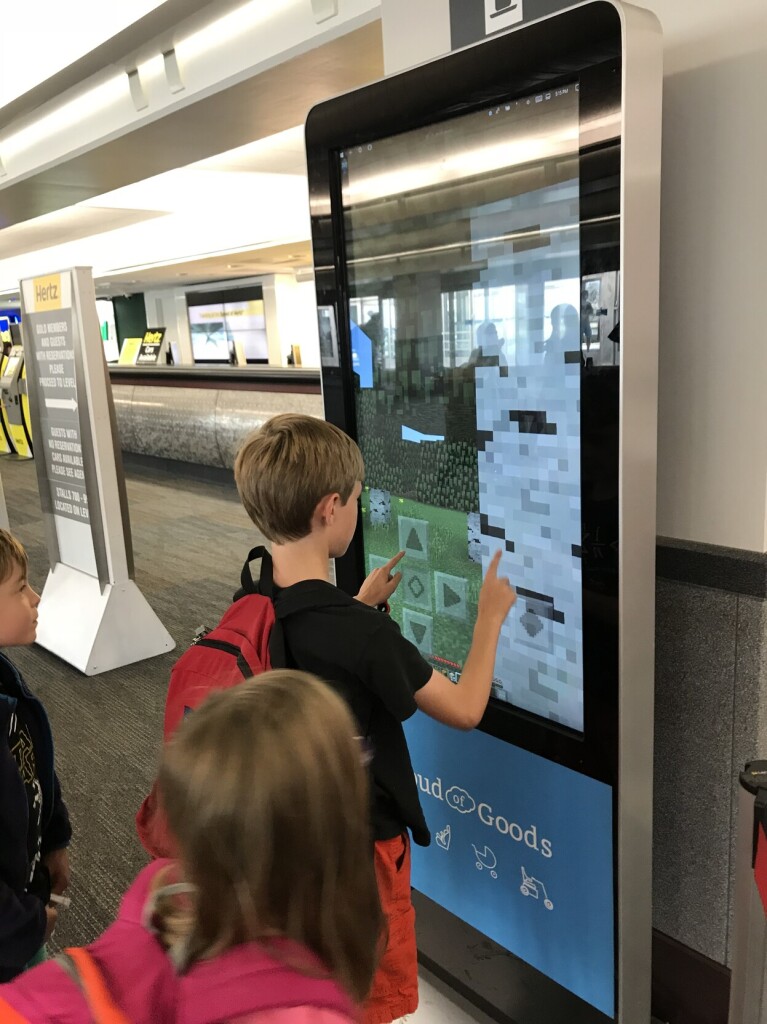 A child playing Minecraft on a large information kiosk