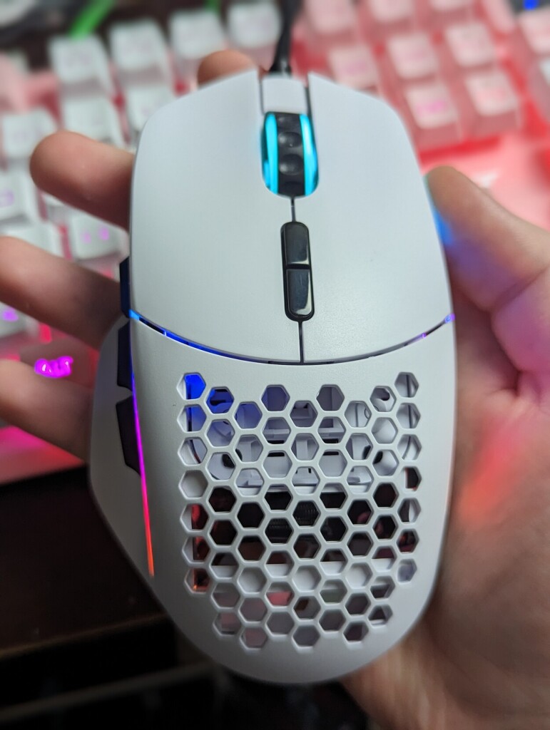 A white computer mouse with a RGB LED design on the wheel and on the left side.