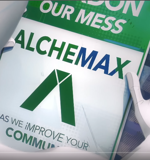 a sign from across the spiderverse that says "pardon our mess as we improve your community" with the alchemax logo on it