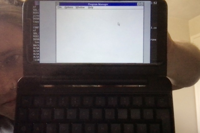 A pinephone with keyboard case running Windows 3.1 in dosbox
