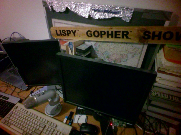 Wires, about 4 monitors and keyboards, a mic, old and sometimes tattered books everywhere. A backwards whiteboard covered in aluminium foil, that had a useful audio application at one point. Casette tapes.