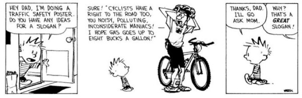 A black-and-white comic strip featuring a child asking his dad for a traffic safety poster slogan. The dad enthusiastically suggests a slogan promoting cyclists' rights and criticizing motorists. The child responds by deciding to ask his mom instead.